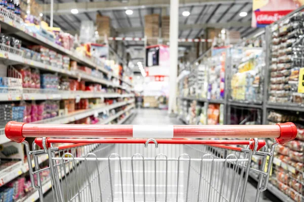 The empty red shopping cart in supermarket with blurred background, Shopping concept.