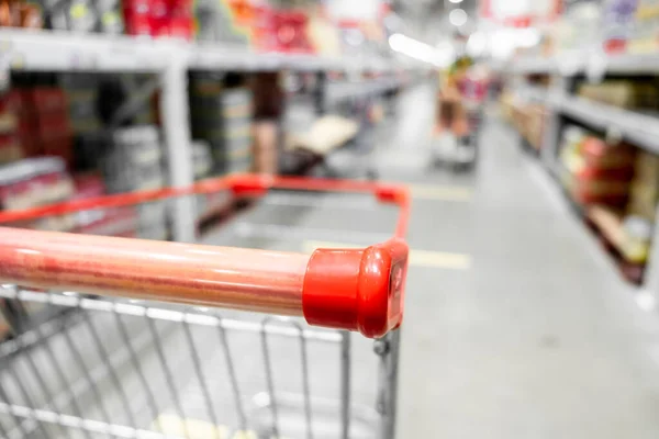 The empty red shopping cart in supermarket with blurred background, Shopping concept.