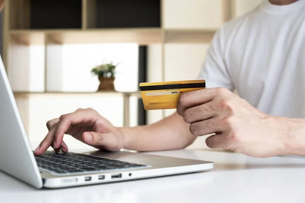 男人的袖珍手握着信用卡 用电脑笔记本上网购物 免版税图库照片