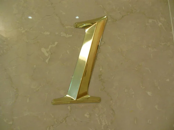 Güzel sayı 1 (bir) basamak mermer zemin üzerine izole altın