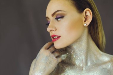 Yaratıcı glitter makyajla güzel kızla parıldıyor. Güzellik bir sanat yüzüdür. Stüdyoda çekilmiş fotoğrafı.