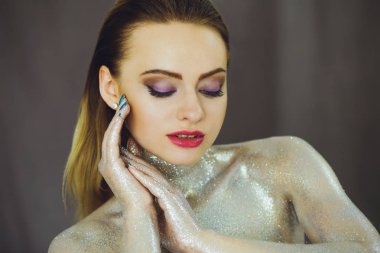 Yaratıcı glitter makyajla güzel kızla parıldıyor. Güzellik bir sanat yüzüdür. Stüdyoda çekilmiş fotoğrafı.