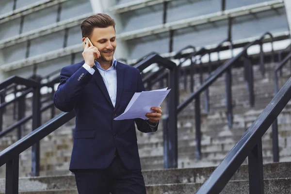Kağıtları, belgeler açık havada, işadamı cep telefonuyla konuşurken iş takım elbiseli adam