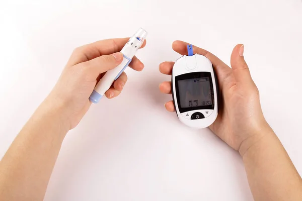 Beyaz arka plan üzerinde izole bir şeker ölçüm ile bir kan testi yaptıkları şeker hastalığı olan bir kişi