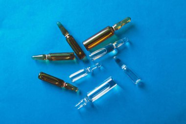 Mavi bir arka plan üzerine açık cam ampul aşı mevcuttur.