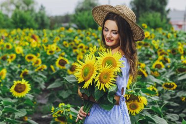 Genç güzel kız elbise ve şapka ayçiçekleri alanı