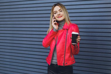 Genç güzel kız içecekler kahve ve telefonda konuşurken