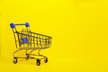 Sarı arka planda alışveriş arabası