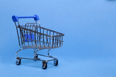 Mavi arka planda alışveriş arabası