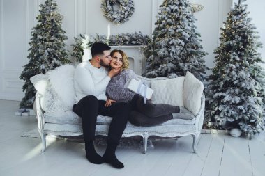 Birbirimize, Noel, yeni yıl ağacı yakınındaki kanepede oturan hafifçe gülümseyerek aşık bir çift