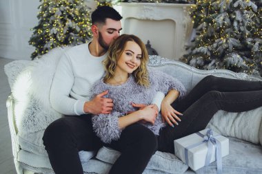 Birbirimize, Noel, yeni yıl ağacı yakınındaki kanepede oturan hafifçe gülümseyerek aşık bir çift