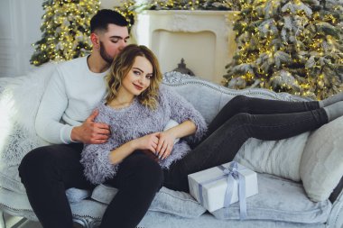 Birbirimize, Noel, yeni yıl ağacı yakınındaki kanepede oturan hafifçe gülümseyerek aşık bir çift