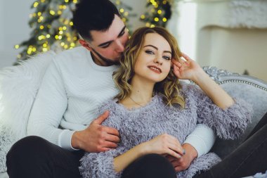 Birbirimize, Noel, yeni yıl ağacı yakınındaki kanepede oturan hafifçe gülümseyerek aşık bir çift