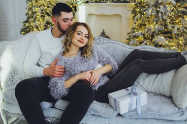 Birbirimize, Noel, yeni yıl ağacı yakınındaki kanepede oturan hafifçe gülümseyerek aşık bir çift