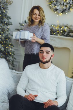 Adam Noel ağacı arka plan üzerinde kız için bir hediye veriyor. Noel arka plan