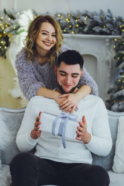 Adam Noel ağacı arka plan üzerinde kız için bir hediye veriyor. Noel arka plan