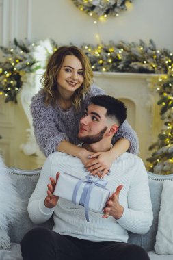 Adam Noel ağacı arka plan üzerinde kız için bir hediye veriyor. Noel arka plan