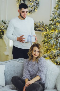 Adam Noel ağacı arka plan üzerinde kız için bir hediye veriyor. Noel arka plan