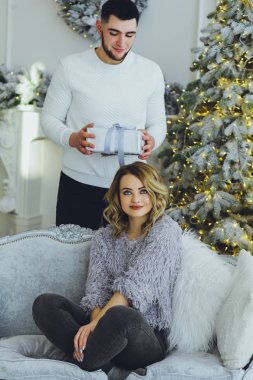 Adam Noel ağacı arka plan üzerinde kız için bir hediye veriyor. Noel arka plan