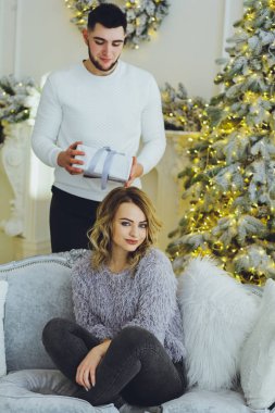 Adam Noel ağacı arka plan üzerinde kız için bir hediye veriyor. Noel arka plan