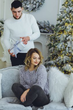 Adam Noel ağacı arka plan üzerinde kız için bir hediye veriyor. Noel arka plan