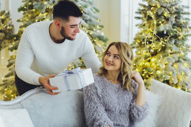 Adam Noel ağacı arka plan üzerinde kız için bir hediye veriyor. Noel arka plan