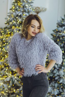 Genç güzel kız sarışın Noel ağacı arka plan üzerinde. Noel arka plan