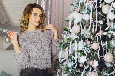 Genç kız güzel bir kazak Noel ağacı süsle