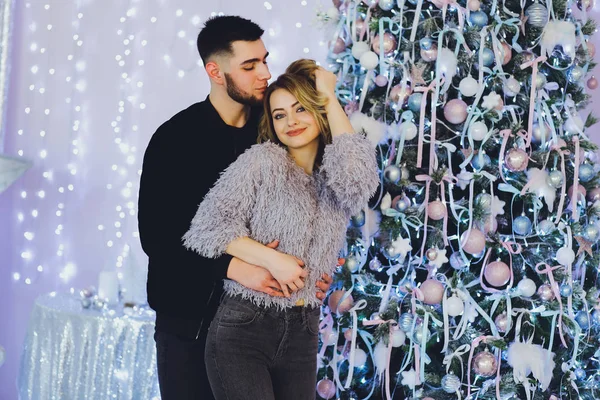 Aşık çift: bir adam ve bir kız Noel ağacı arka plan üzerinde? Noel arka plan
