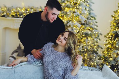 Aşık çift: bir adam ve bir kız Noel ağacı arka plan üzerinde. Noel arka plan 