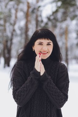 Karlı kış ormandaki bir kazaklı genç güzel esmer kız