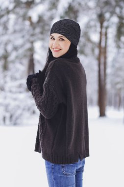 Karlı kış ormandaki bir kazaklı genç güzel esmer kız