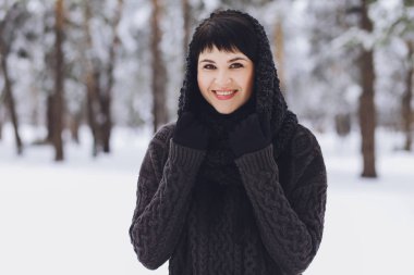 Karlı kış ormandaki bir kazaklı genç güzel esmer kız