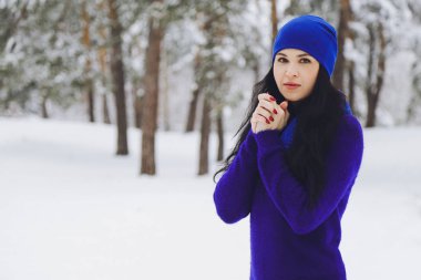 Karlı kış ormandaki bir kazaklı genç güzel esmer kız
