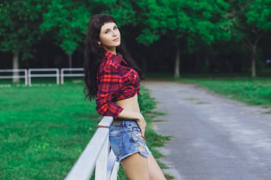 Şort ve tişört arka plan yeşil çim üzerinde yaz parkta genç güzel esmer kız