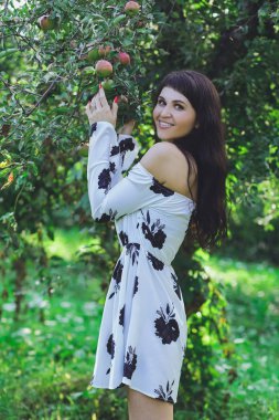 Yaz parkta yeşil çim zemin üzerine beyaz bir elbise genç güzel esmer kız