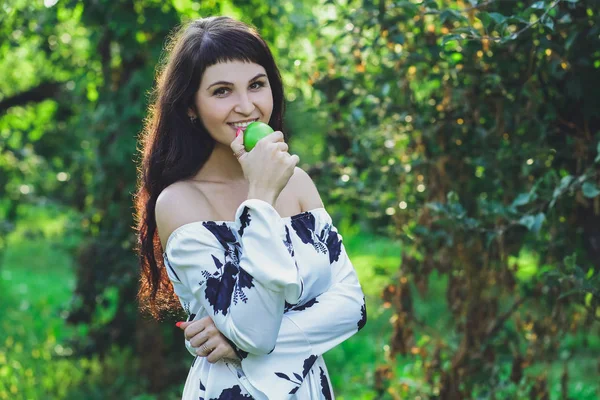 Yaz parkta yeşil çim zemin üzerine beyaz bir elbise genç güzel esmer kız