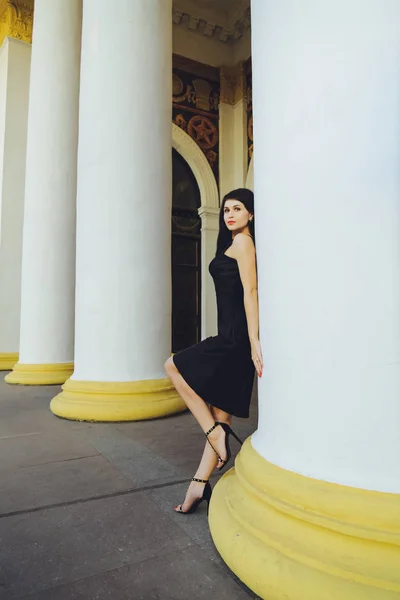 Menina Morena Bonita Nova Vestido Preto Perto Das Colunas Brancas — Fotografia de Stock