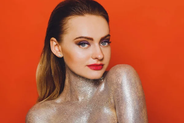 Yüksek moda modeli kız renkli parlak payetler, glitter, üzerinde kırmızı bir arka plan, güzel bir seksi kadın, makyaj moda parlak portre Studio. Renkli parlak parlak makyaj