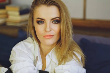 Genç güzel sarışın kız yatakta bir beyaz erkek gömlek