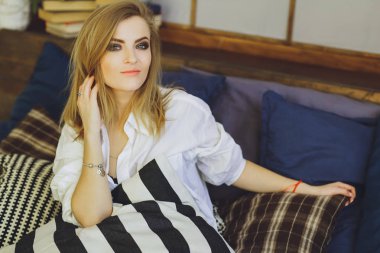 Genç güzel sarışın kız yatakta bir beyaz erkek gömlek