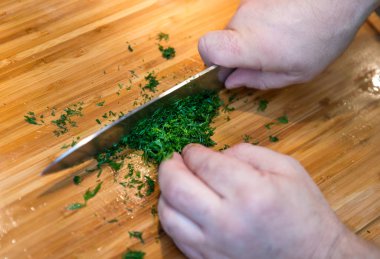 Ahşap kesme tahtası üzerinde adam kesme dill bıçakla görünümü Kapat