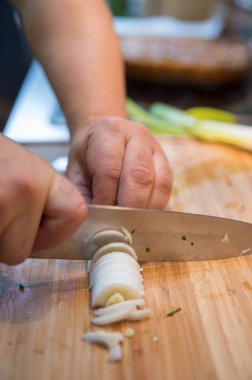 Ahşap kesme tahtası üzerinde bıçakla adam kesme pırasa görünümünü kapat