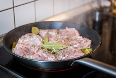 Tavuk bacağı biftek üzerinde beyaz şarap soslu otlar baharat ve tavada ızgara soğan ile