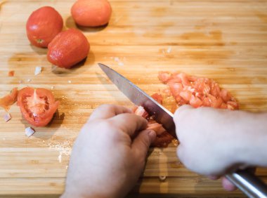 Kesme ve ahşap plaka üzerinde bıçakla domates doğrama dostum