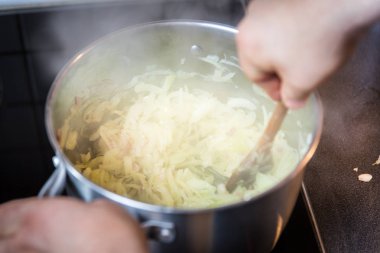 kaşık tencerede ile soğan dilimleri karıştırma adam yakın çekim 