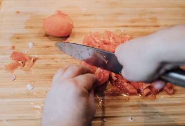 Kesme ve ahşap plaka üzerinde bıçakla domates doğrama dostum