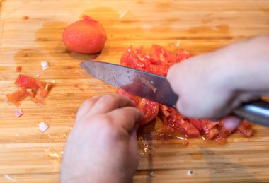 Kesme ve ahşap plaka üzerinde bıçakla domates doğrama dostum