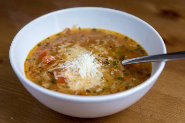 İtalyan soğan çorbası domates ve fesleğen ile ahşap zemin üzerine parmesan peyniri serpilir