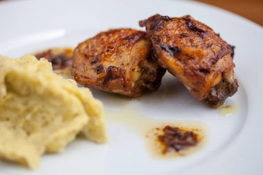 Beyaz tabakta patates püresi ile beyaz şarap soslu ve soğan tavuk bacak biftek pişmiş, yakın-up 